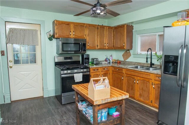 804 Hollywood Ave, East Liverpool, OH 43920 - kitchen with stainless steel appliances, a sink, a ceiling fan, and brown cabinets