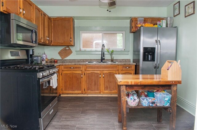 804 Hollywood Ave, East Liverpool, OH 43920 - kitchen featuring appliances with stainless steel finishes, a sink, brown cabinetry, and baseboards