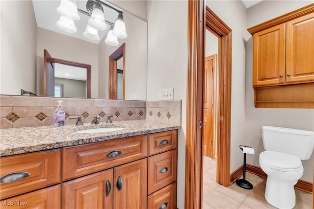bathroom with tile patterned floors, toilet, vanity, decorative backsplash, and a chandelier