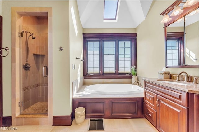bathroom with a stall shower, plenty of natural light, a garden tub, vanity, and vaulted ceiling