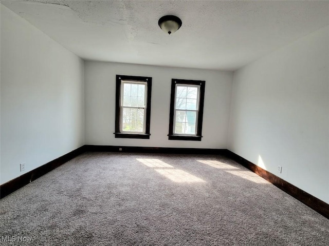 621 Noah Ave, Akron, OH 44320 - carpeted spare room with baseboards and a textured ceiling