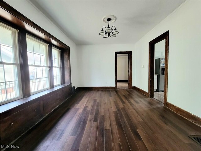 621 Noah Ave, Akron, OH 44320 - unfurnished dining area featuring dark wood-type flooring, baseboards, and a chandelier