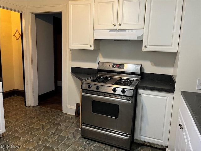 3657 Ludgate Rd, Shaker Heights, OH 44120 - kitchen with under cabinet range hood, stainless steel range with gas cooktop, dark countertops, and white cabinetry