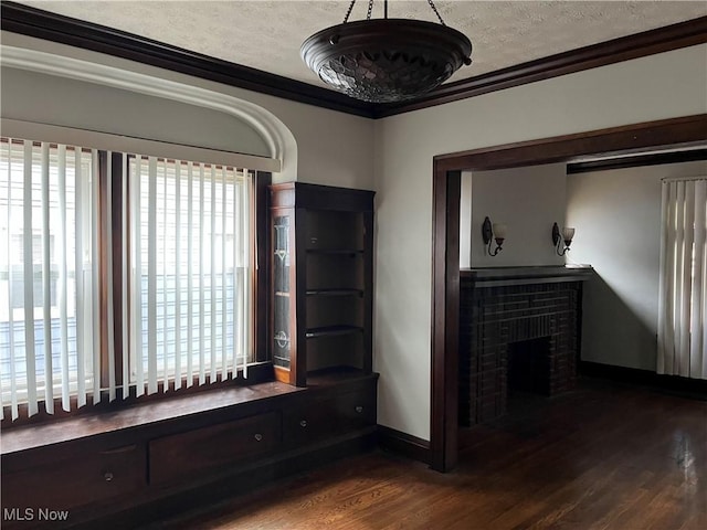 3657 Ludgate Rd, Shaker Heights, OH 44120 - unfurnished room featuring dark wood-style flooring, ornamental molding, baseboards, a brick fireplace, and a textured ceiling