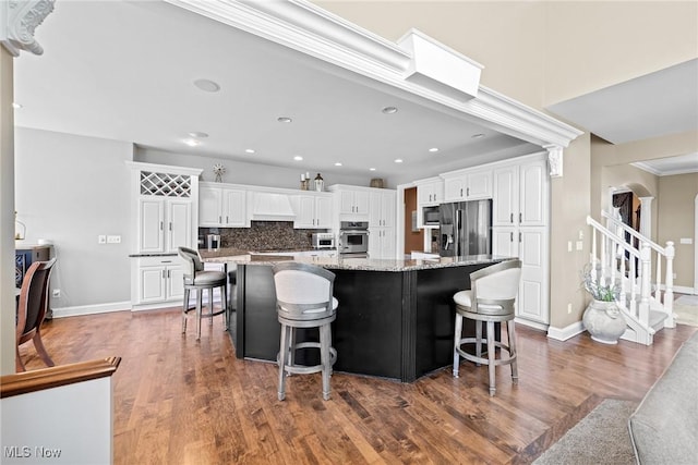 915 Creek View Dr, Aurora, OH 44202 - kitchen with stainless steel appliances, white cabinets, wood finished floors, decorative backsplash, and light stone countertops