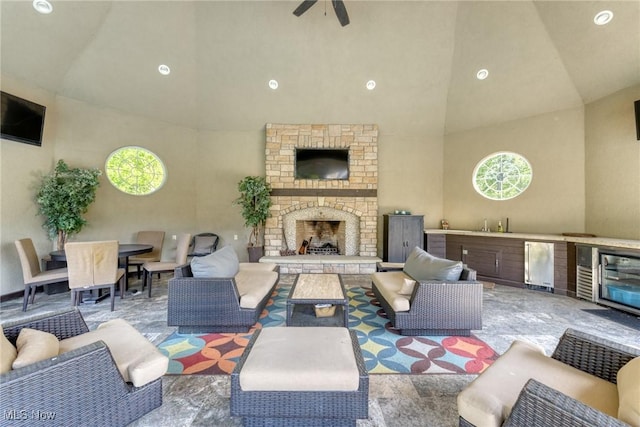 915 Creek View Dr, Aurora, OH 44202 - living area with wine cooler, high vaulted ceiling, healthy amount of natural light, a stone fireplace, and ceiling fan