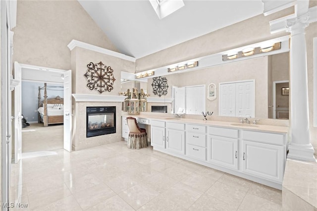 915 Creek View Dr, Aurora, OH 44202 - ensuite bathroom featuring high vaulted ceiling, double vanity, a multi sided fireplace, and ornate columns