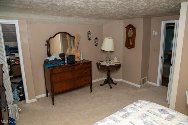 bedroom with carpet floors, a textured ceiling, and baseboards