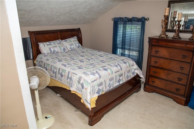 carpeted bedroom featuring lofted ceiling and a textured ceiling