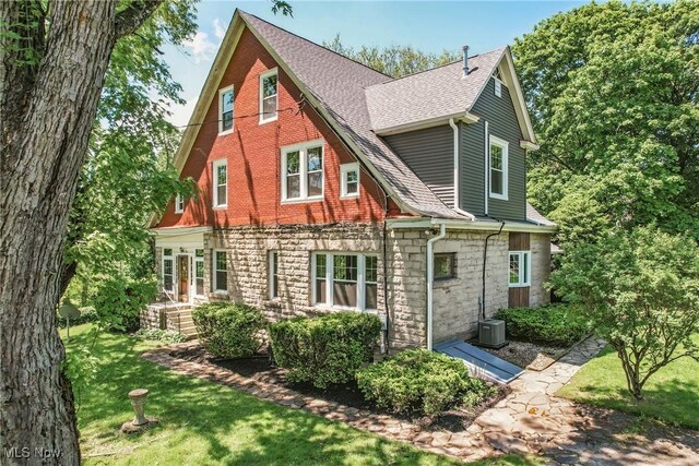 899 Park Blvd W, East Liverpool, OH 43920 - rear view of property with stone siding, roof with shingles, a yard, and central AC unit
