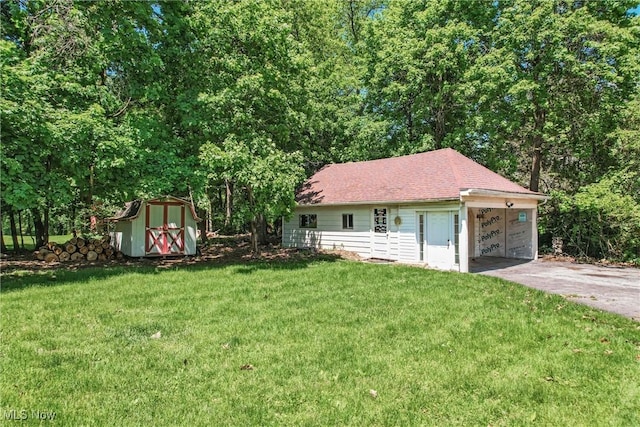 899 Park Blvd W, East Liverpool, OH 43920 - view of front of property featuring asphalt driveway, an outdoor structure, a front lawn, a storage unit, and a garage