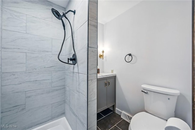 899 Park Blvd W, East Liverpool, OH 43920 - bathroom featuring vanity, a tile shower, toilet, tile patterned flooring, and baseboards