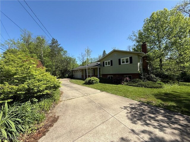 6855 Painesville Ravenna Rd, Concord, OH 44077 - split level home with concrete driveway, a chimney, and a front yard