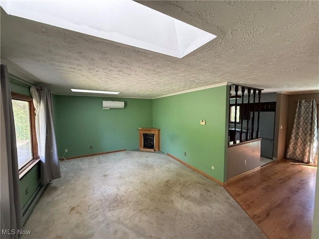 6855 Painesville Ravenna Rd, Concord, OH 44077 - unfurnished living room with an AC wall unit, a textured ceiling, a fireplace with raised hearth, baseboards, and a skylight
