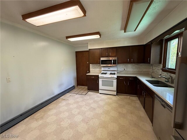 6855 Painesville Ravenna Rd, Concord, OH 44077 - kitchen featuring stainless steel appliances, a sink, light countertops, dark brown cabinetry, and decorative backsplash