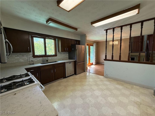 6855 Painesville Ravenna Rd, Concord, OH 44077 - kitchen featuring stainless steel appliances, light countertops, a sink, dark brown cabinetry, and light flooring