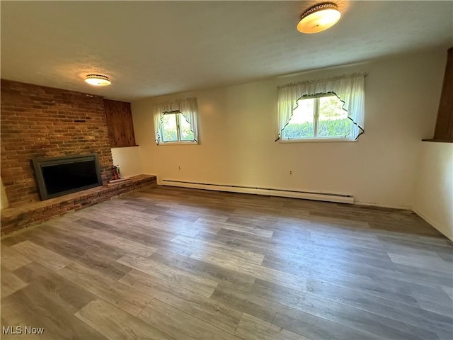 6855 Painesville Ravenna Rd, Concord, OH 44077 - unfurnished living room with baseboard heating, a brick fireplace, and wood finished floors