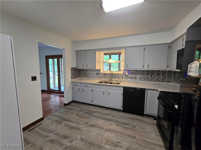 1308 17th St, Vienna, WV 26105 - kitchen with black appliances, a sink, backsplash, and light countertops