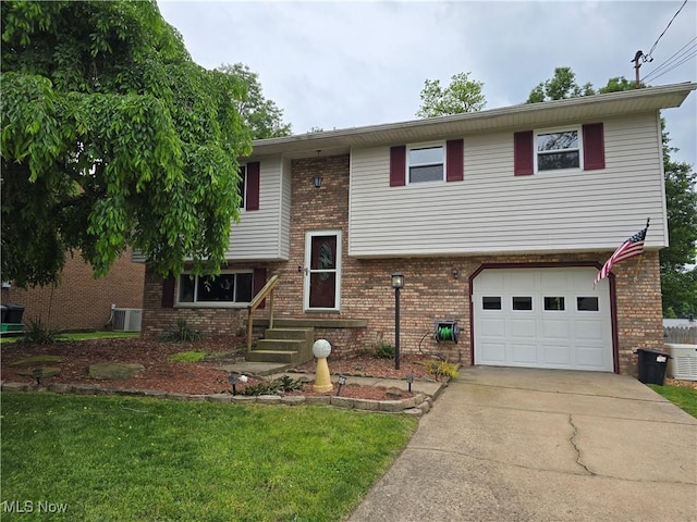 1308 17th St, Vienna, WV 26105 - split foyer home with a garage, driveway, brick siding, and central AC unit