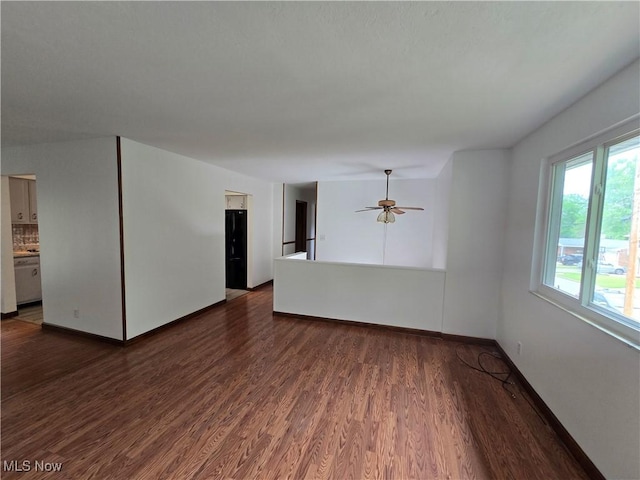 1308 17th St, Vienna, WV 26105 - unfurnished living room featuring dark wood-style flooring, a ceiling fan, and baseboards