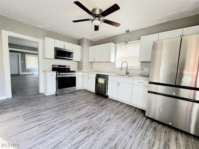 432 Fuller St, Akron, OH 44306 - kitchen featuring stainless steel appliances, a sink, light wood finished floors, light countertops, and white cabinetry