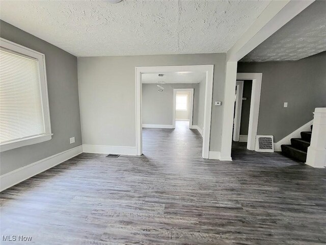 432 Fuller St, Akron, OH 44306 - empty room with a textured ceiling, dark wood-type flooring, stairs, and baseboards