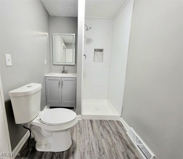 432 Fuller St, Akron, OH 44306 - full bath with wood finished floors, a shower stall, toilet, vanity, and a textured ceiling