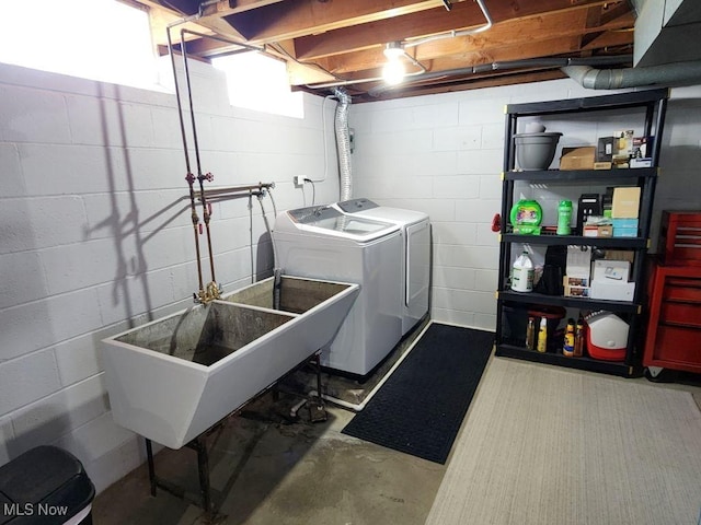 clothes washing area featuring washing machine and dryer and concrete block wall