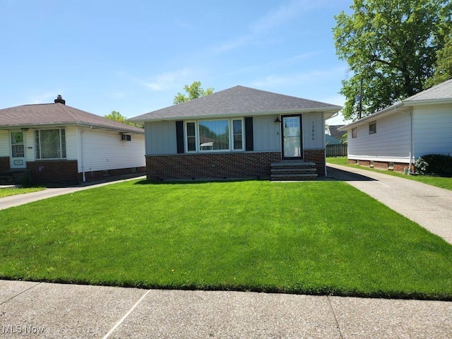 bungalow-style house featuring brick siding, a front yard, board and batten siding, and entry steps