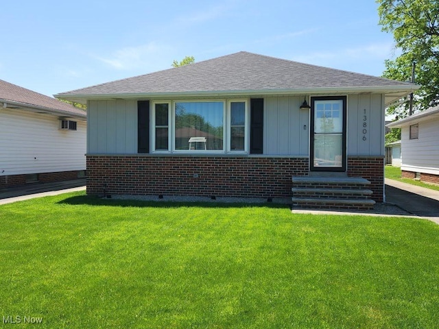 bungalow-style home featuring crawl space, brick siding, and a front lawn