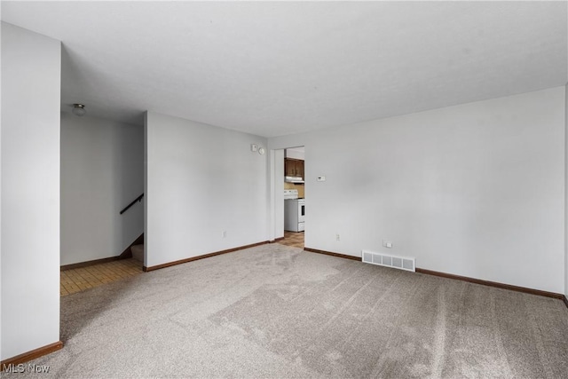 carpeted spare room featuring baseboards