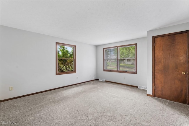 unfurnished bedroom featuring carpet flooring and baseboards