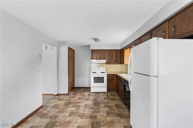 kitchen featuring white appliances, under cabinet range hood, stone finish floors, baseboards, and light countertops
