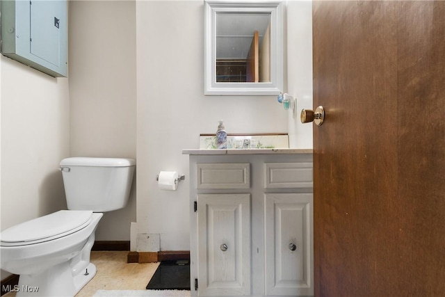 bathroom featuring vanity, toilet, baseboards, and tile patterned floors