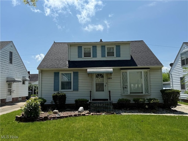 bungalow-style home featuring a front yard and a shingled roof