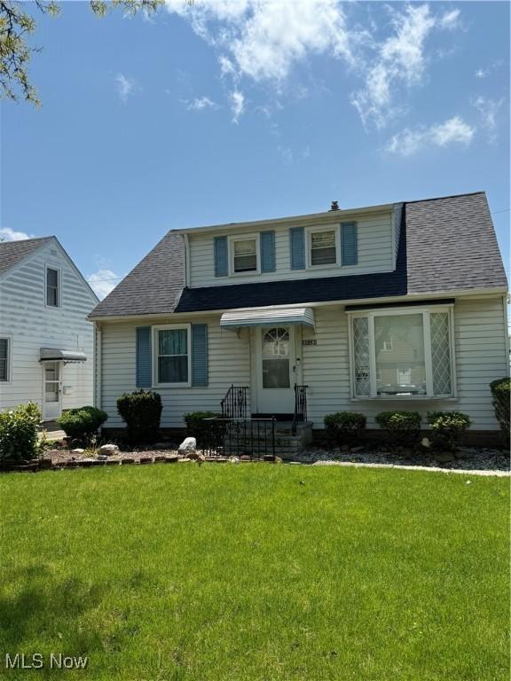 bungalow featuring a front yard and roof with shingles
