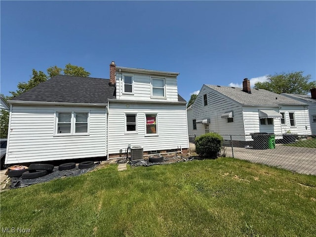 back of property with central AC, a chimney, and a shingled roof