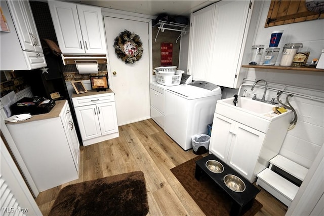 50277 Carroll Rd, East Liverpool, OH 43920 - laundry room featuring washer and clothes dryer, light wood finished floors, and cabinet space