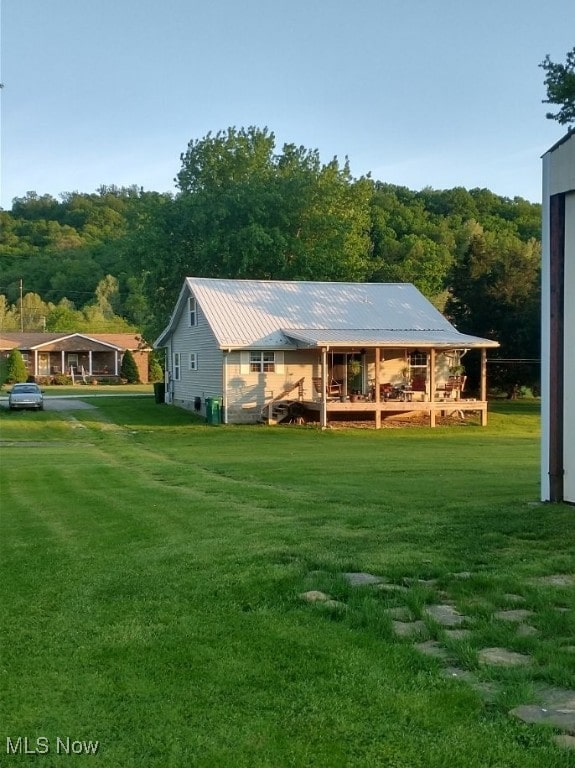 297 Hales Lndg, Elizabeth, WV 26143 - back of property with a lawn, metal roof, and a forest view