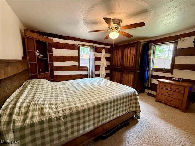 6141 Avon Rd NE, Carrollton, OH 44615 - bedroom with multiple windows, a textured ceiling, a ceiling fan, and light colored carpet