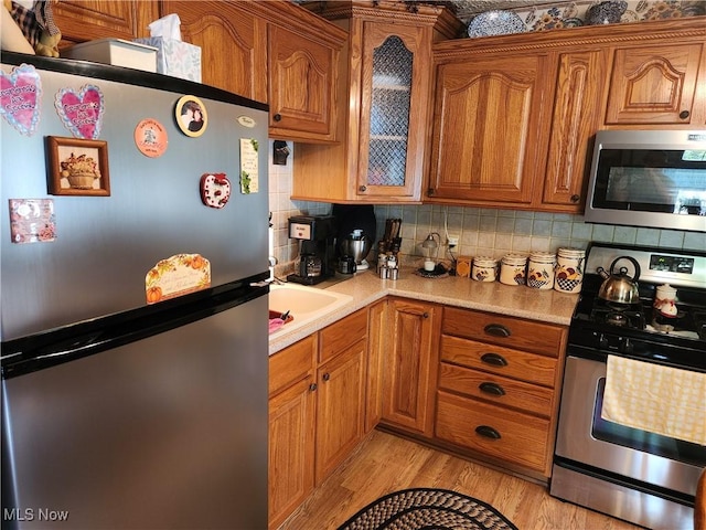 867 S 14th St, Sebring, OH 44672 - kitchen with stainless steel appliances, brown cabinetry, and light countertops