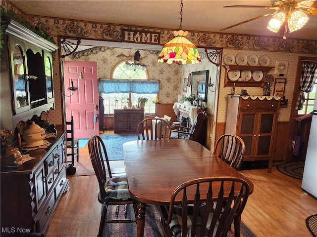 867 S 14th St, Sebring, OH 44672 - dining space with wallpapered walls, a wainscoted wall, light wood finished floors, and ceiling fan