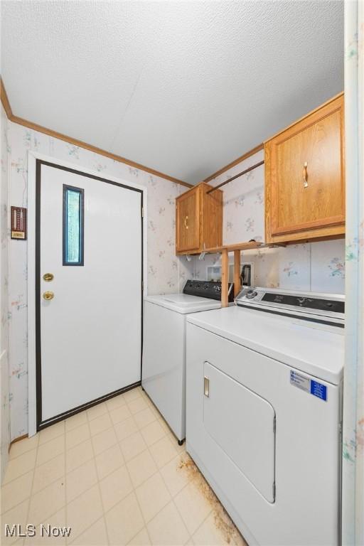 8 Maple Dr, Olmsted Twp, OH 44138 - laundry area with wallpapered walls, cabinet space, washer and clothes dryer, crown molding, and a textured ceiling