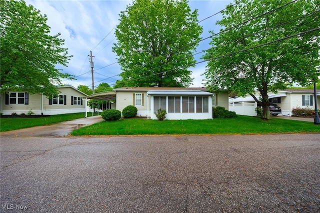 8 Maple Dr, Olmsted Twp, OH 44138 - view of front of house featuring asphalt driveway, a sunroom, a front lawn, and an attached carport
