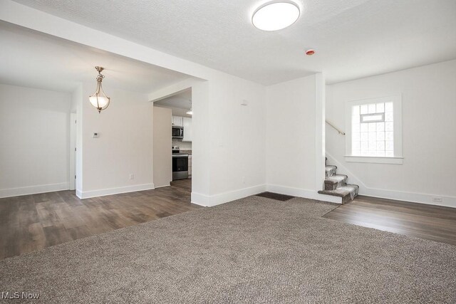 1197 E Ave, Akron, OH 44307 - spare room featuring dark wood-type flooring, baseboards, stairway, and a textured ceiling