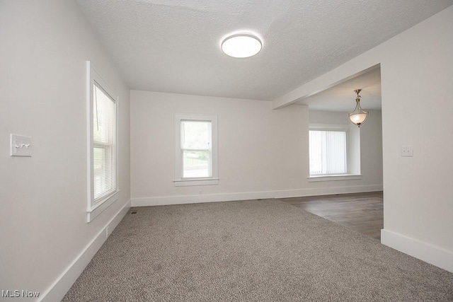 1197 E Ave, Akron, OH 44307 - unfurnished room with healthy amount of natural light, carpet, a textured ceiling, and baseboards