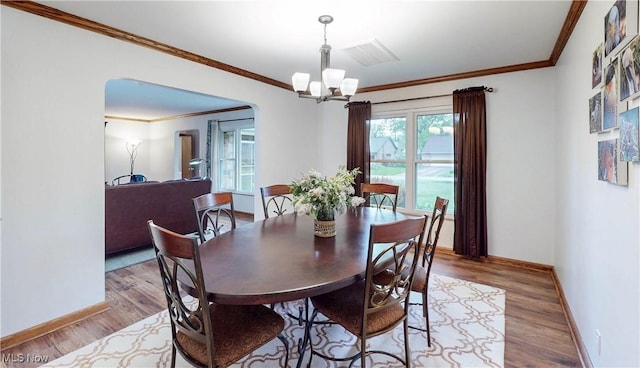 891 Sovereign Rd, Akron, OH 44303 - dining room featuring a chandelier, arched walkways, wood finished floors, and crown molding