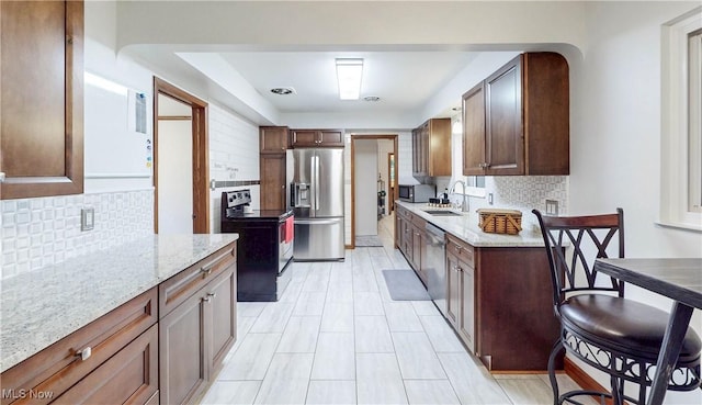 891 Sovereign Rd, Akron, OH 44303 - kitchen with appliances with stainless steel finishes, decorative backsplash, and light stone counters