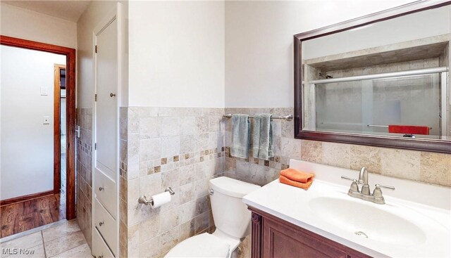 891 Sovereign Rd, Akron, OH 44303 - bathroom with vanity, a shower with door, tile walls, tile patterned flooring, and a wainscoted wall