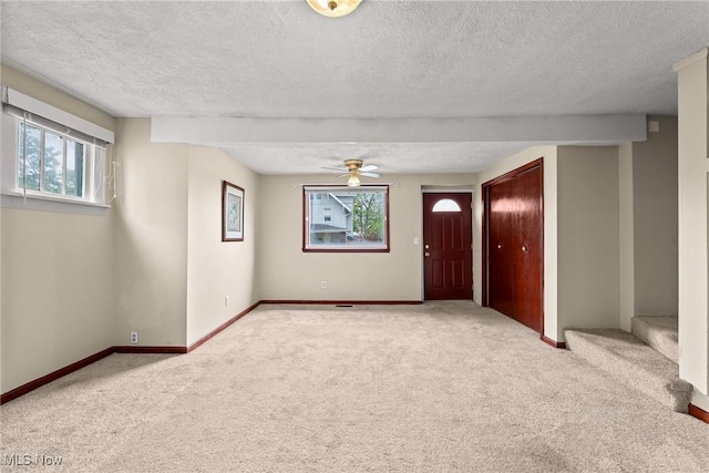 2021 17th St NE, Canton, OH 44705 - empty room featuring carpet, a textured ceiling, baseboards, a ceiling fan, and stairs